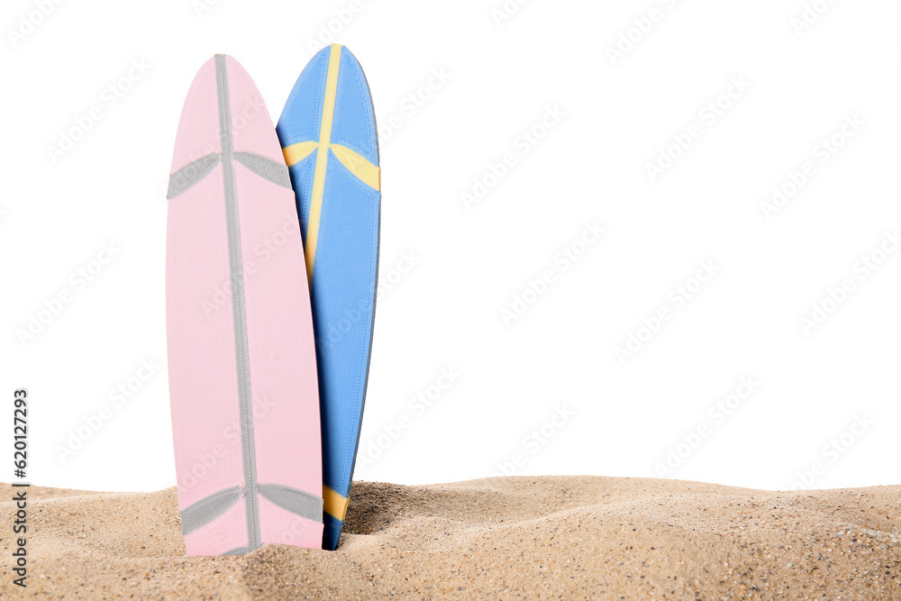 Different colorful mini surfboards on sand against white background