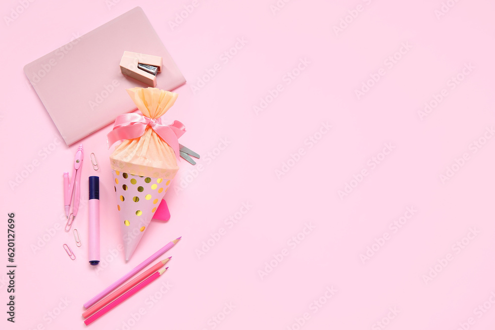 School cone with different stationery on pink background