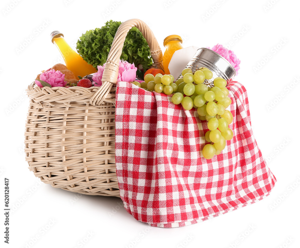 Wicker basket with tasty food for picnic, juice and peony flowers on white background