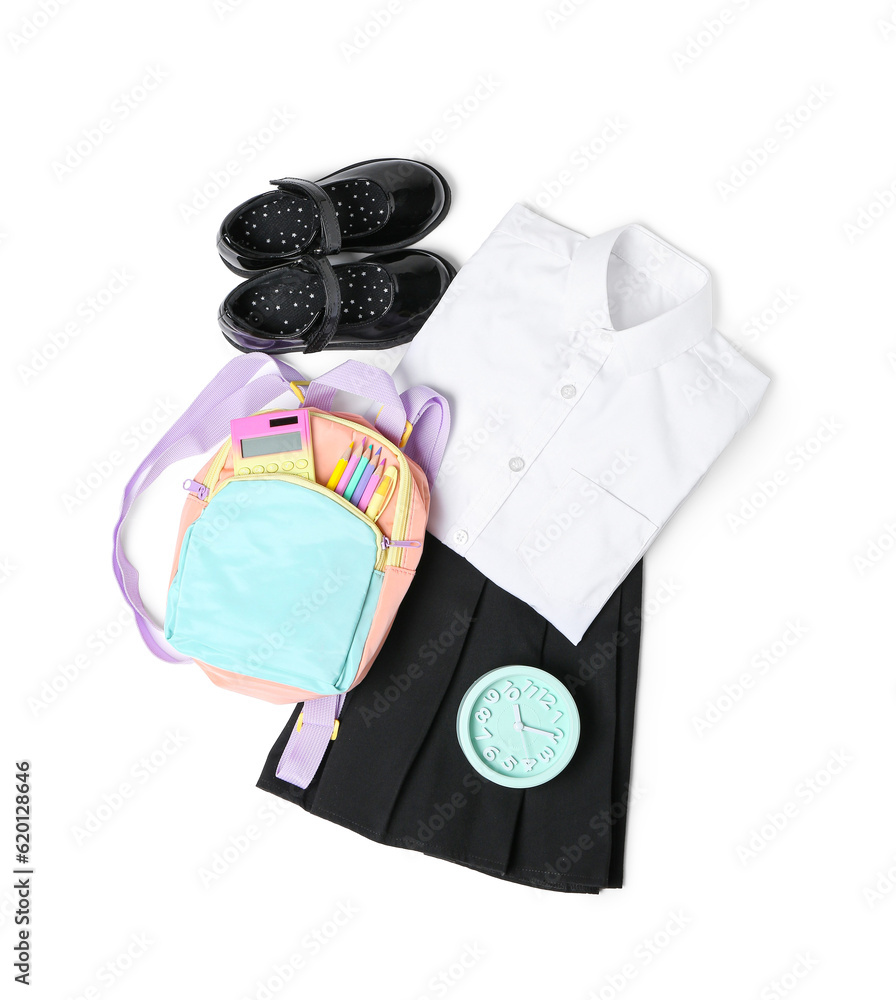 Stylish school uniform with alarm clock, backpack and stationery isolated on white background