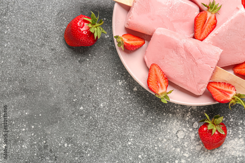 Plate with sweet strawberry ice-cream popsicles on grey background