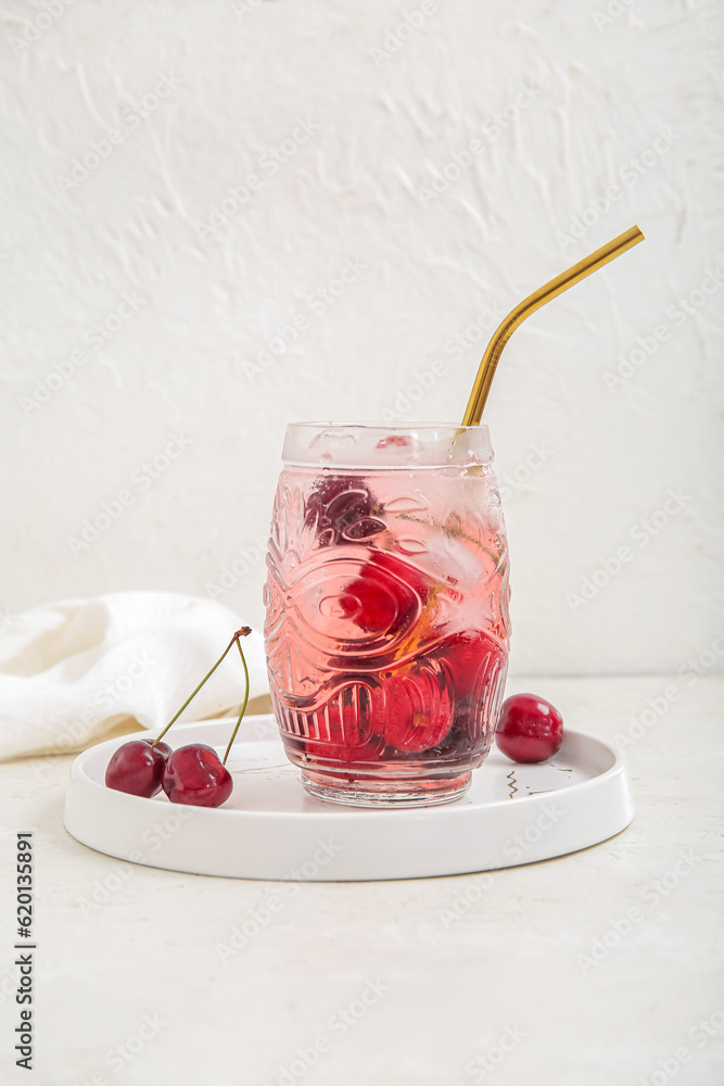 Glass of tasty cherry lemonade on white background