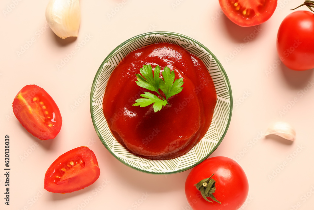 Bowl with tomato paste and fresh vegetables on light background