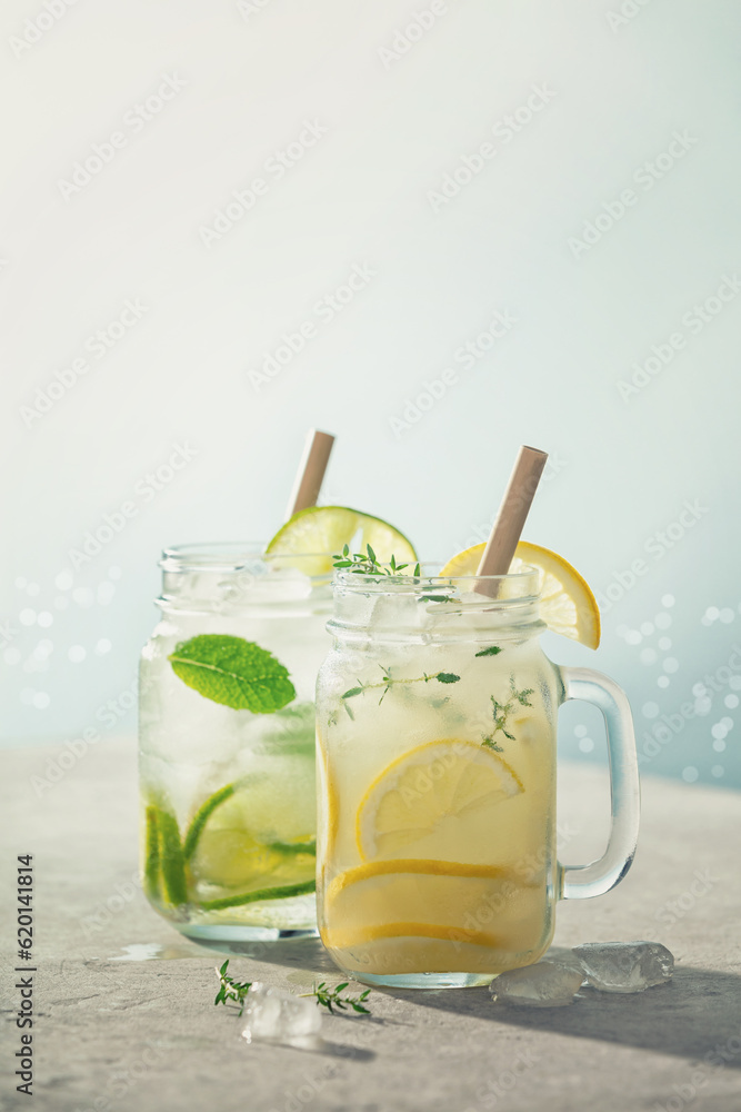 Summer detox and refreshing drinks with lime, lemon, mint and rosemary on blue sea and sky backgroun