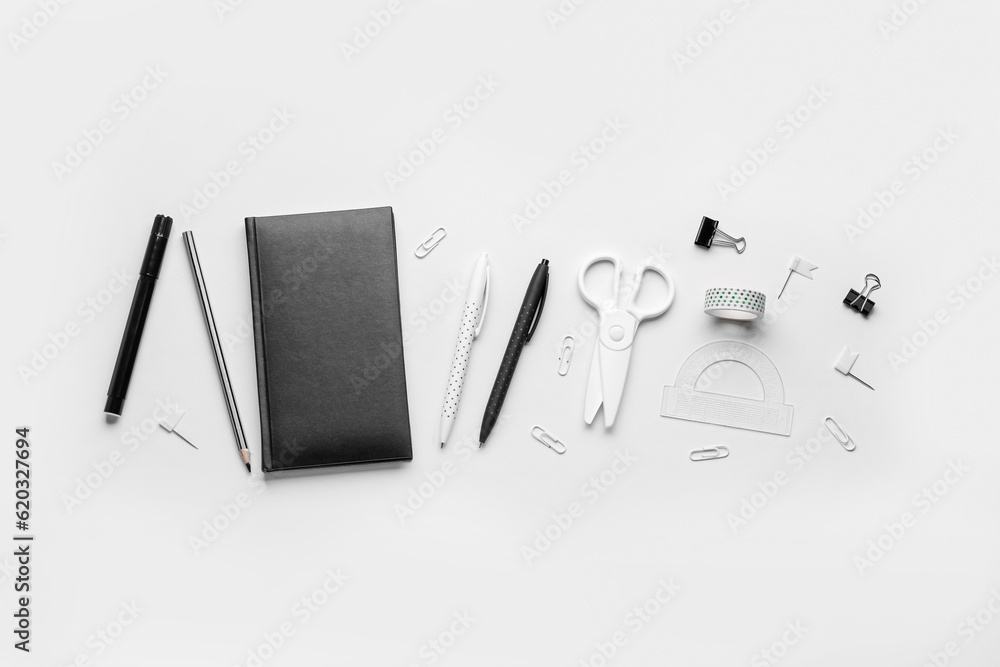 Set of different stationery with notebook on light background