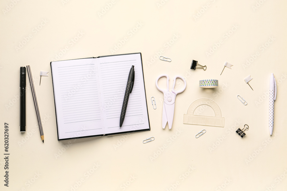 Set of different stationery with blank open notebook on light background