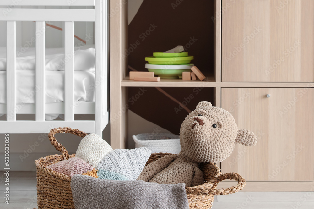 Basket with knitted toys in childrens room