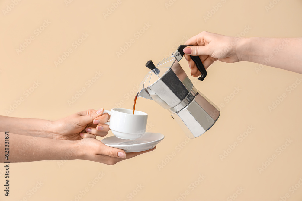 Woman pouring espresso from geyser coffee maker into cup on beige background