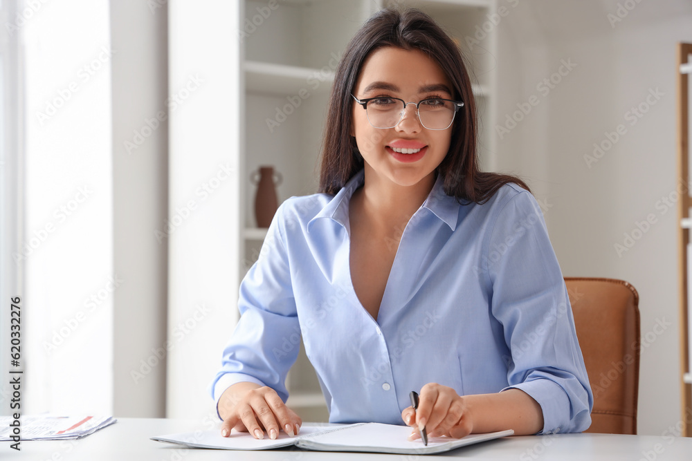 Beautiful young woman wearing glasses while working in office