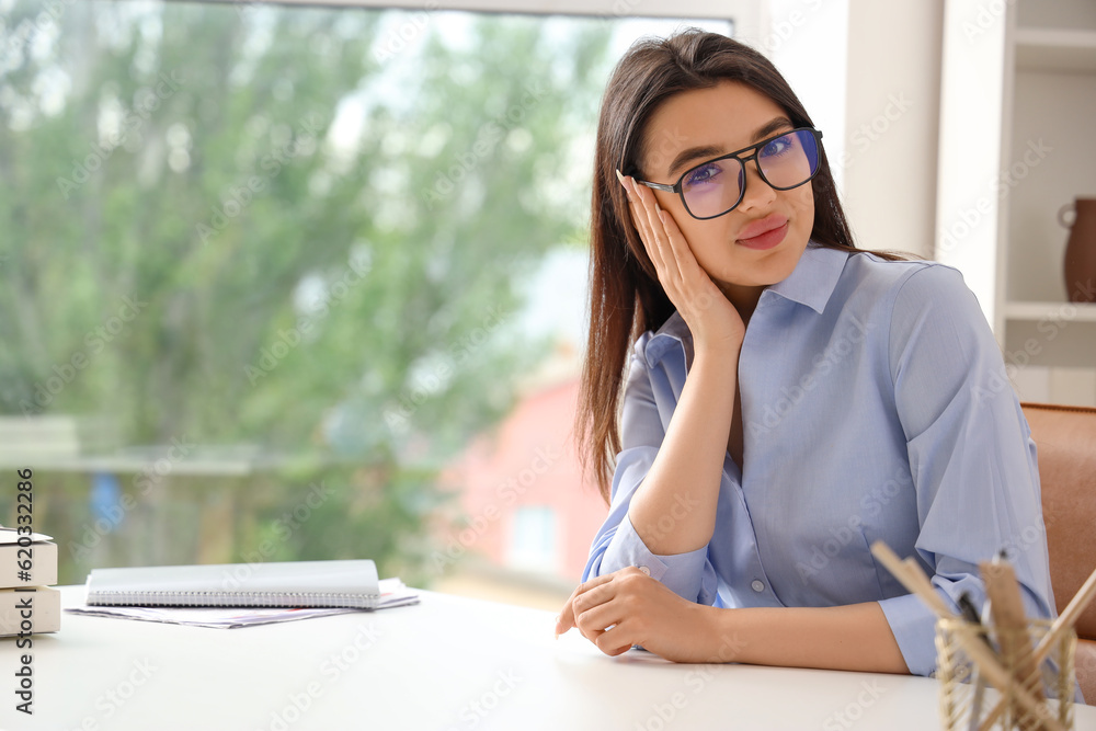 Beautiful young woman wearing glasses in office