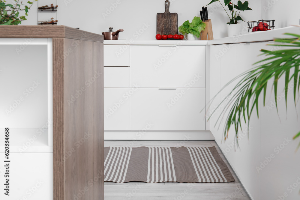 Stylish striped rug in interior of modern kitchen