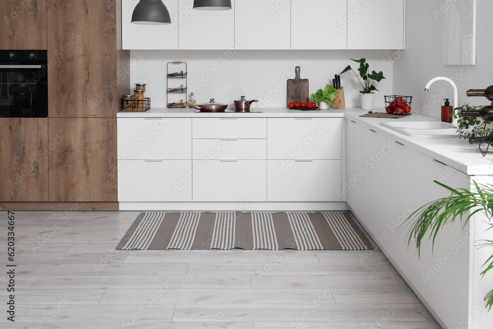 Stylish striped rug in interior of modern kitchen