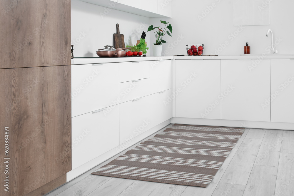 Stylish striped rug in interior of modern kitchen