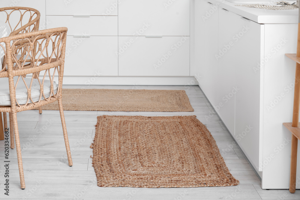 Stylish wicker rugs in interior of modern kitchen