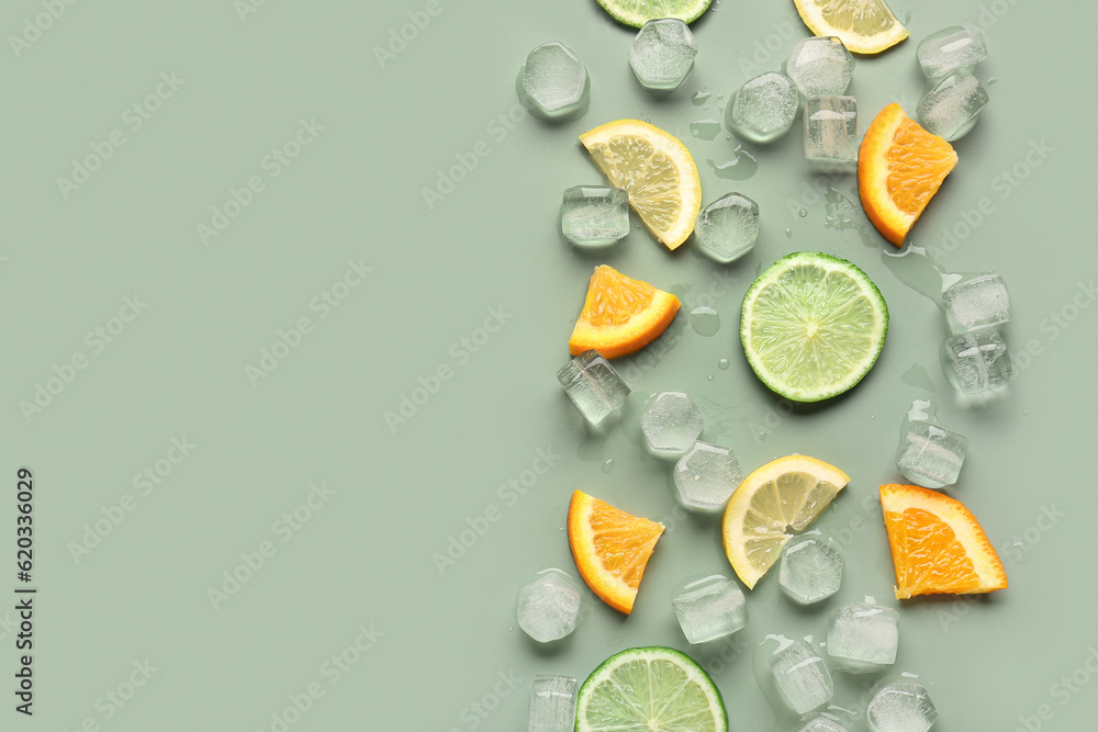 Citrus slices with ice cubes on green background