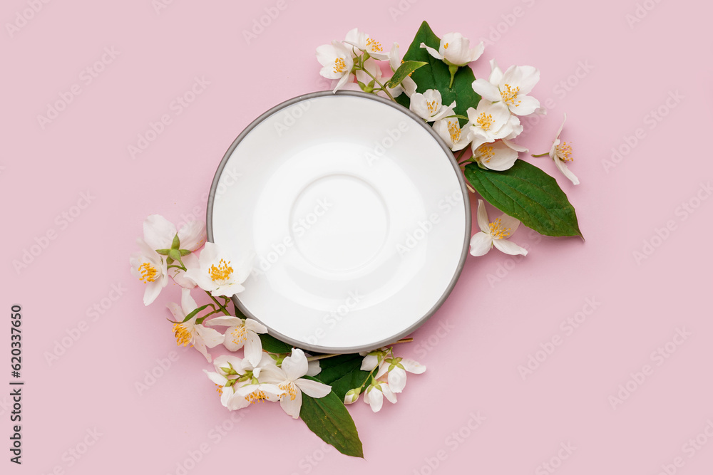 Composition with plate and beautiful jasmine flowers on pink background