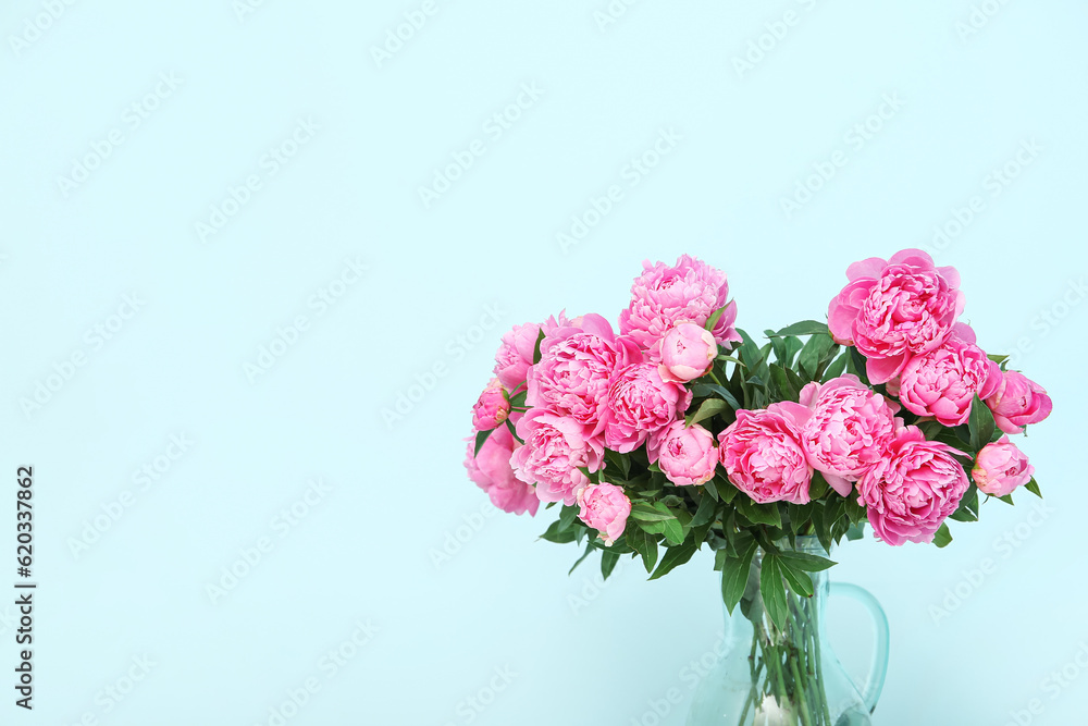 Vase of pink peonies on blue background