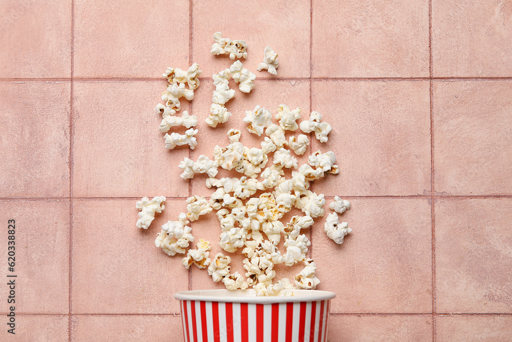 Bucket with tasty popcorn on pink tile background