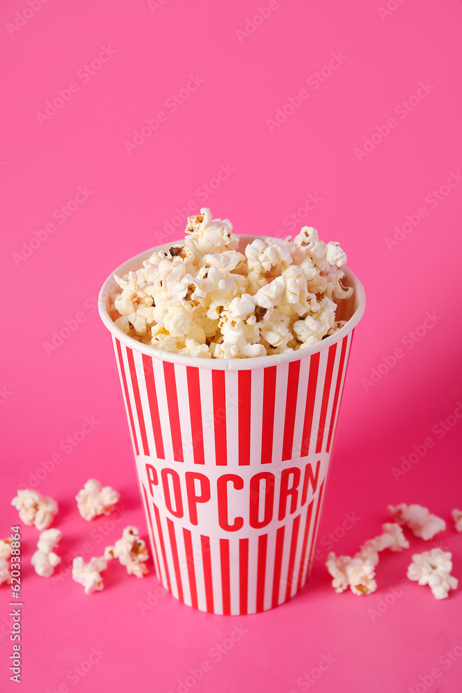 Bucket with tasty popcorn on pink background