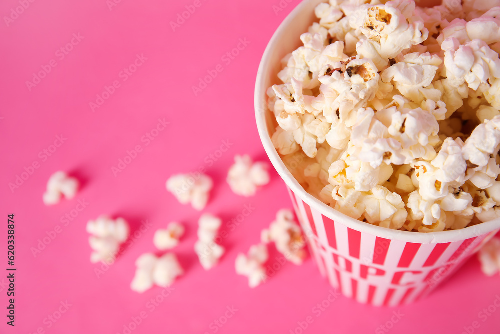 Bucket with tasty popcorn on pink background