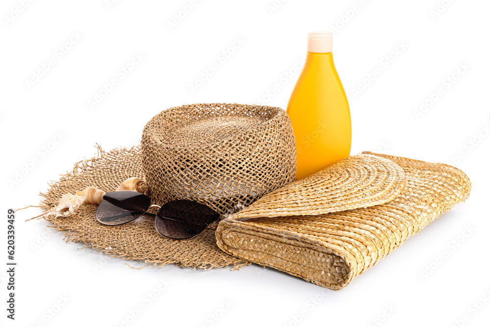 Wicker bag with sunglasses, hat and bottle of sunscreen cream isolated on white background