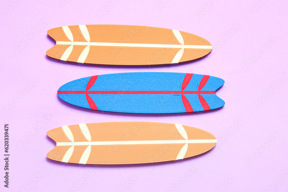 Different mini surfboards on lilac background