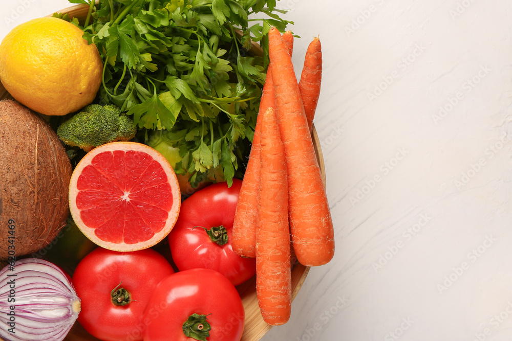 Bowl with different fresh fruits and vegetables on white background, closeup