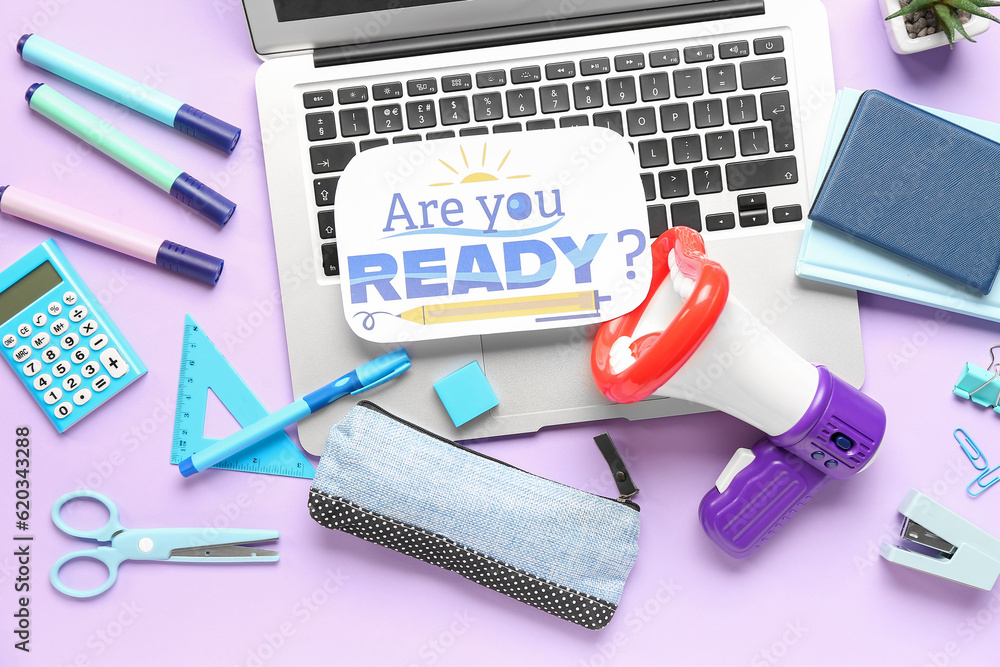 Stationery, laptop, megaphone and sheet with question ARE YOU READY? on lilac background