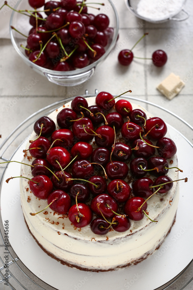 Grid with tasty cherry cake on white tile background