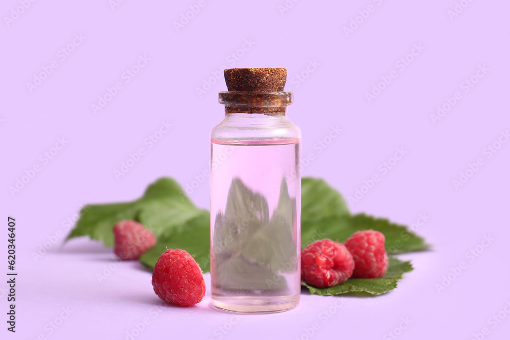 Bottle of cosmetic raspberry oil on lilac background