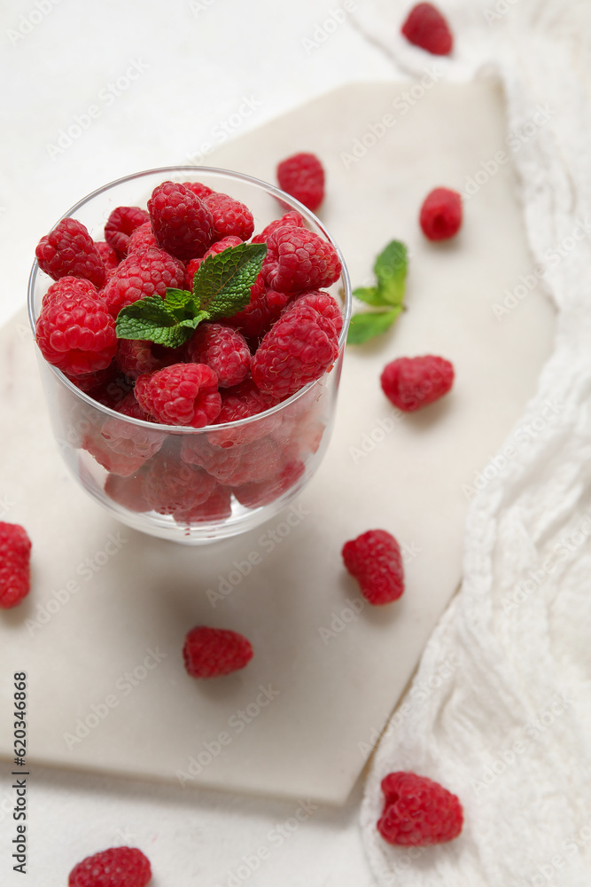 Glass with fresh raspberry and mint on light background, closeup