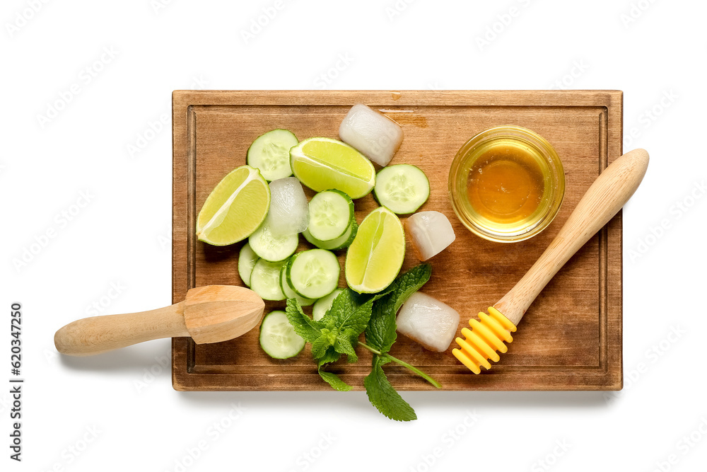 Wooden cutting board with cucumber, mint and honey on white background. Ingredients for mojito