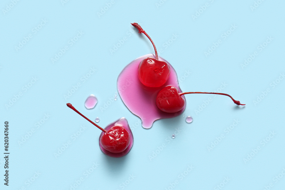 Tasty maraschino cherries on blue background