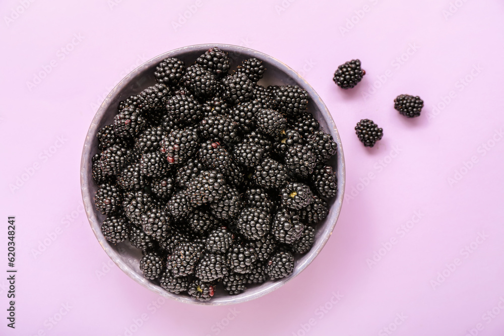 Bowl with fresh blackberry on light background