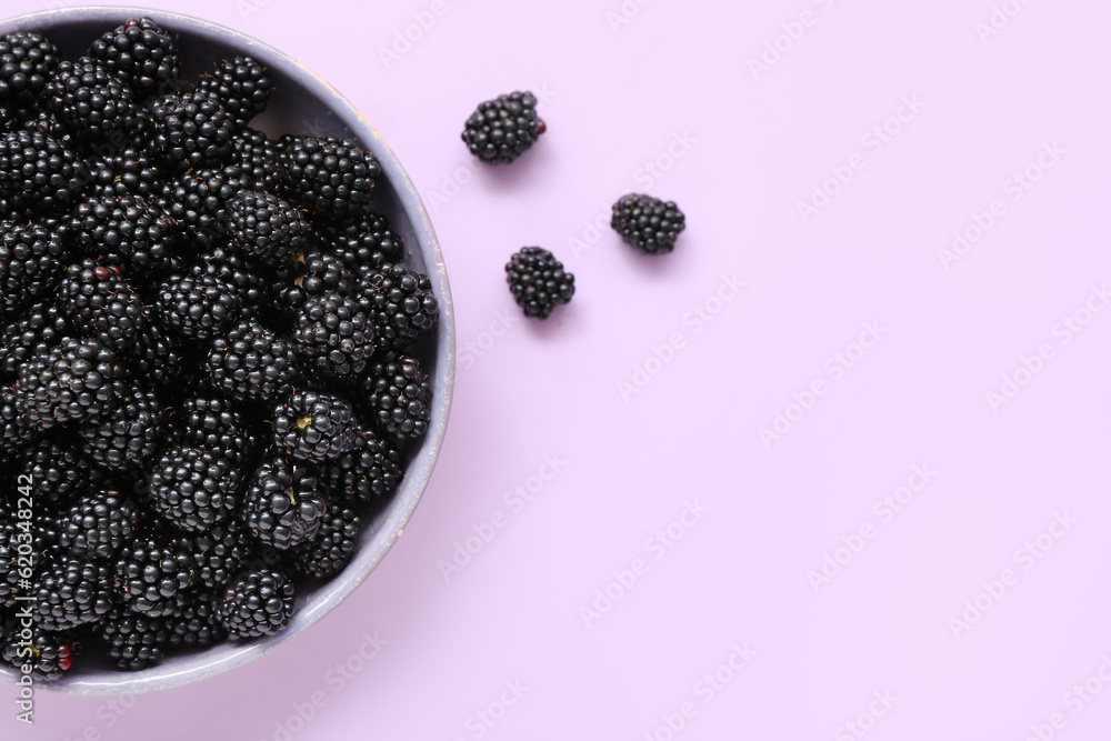 Bowl with fresh blackberry on light background, closeup