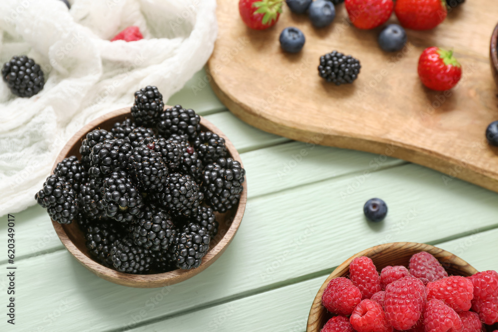 Composition with different fresh berries on color wooden background, closeup