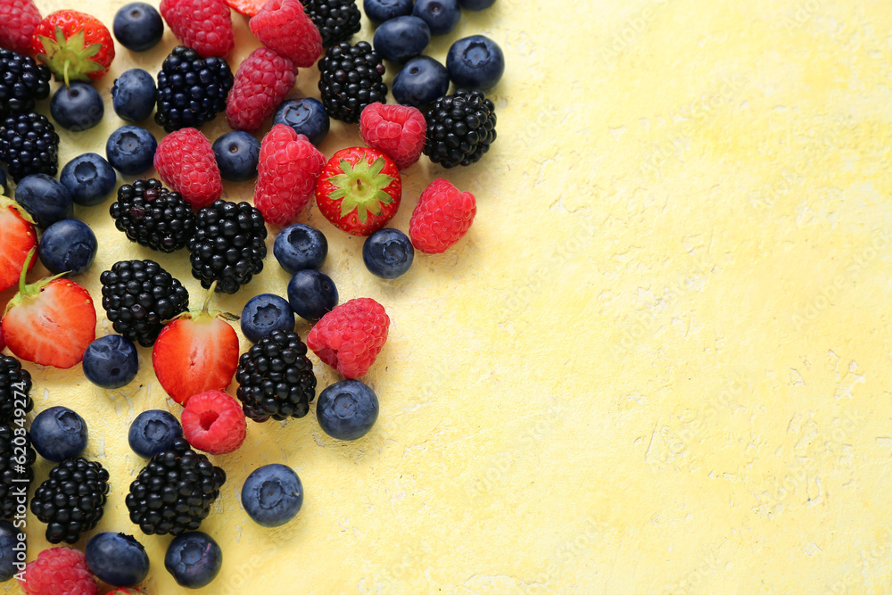 Different fresh berries on yellow background, closeup