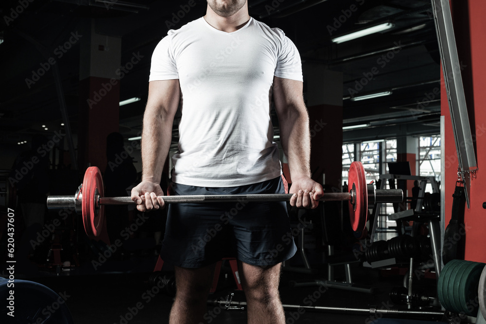 Male athlete lifts the barbell