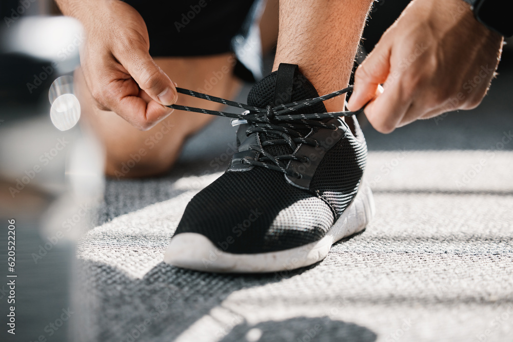 Exercise, shoes and tie laces with a man in a sports gym getting ready for a cardio or endurance wor