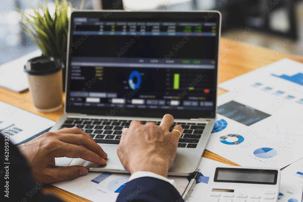 Businessman working on documents on the desk, data analysis of financial figures on laptop and busin