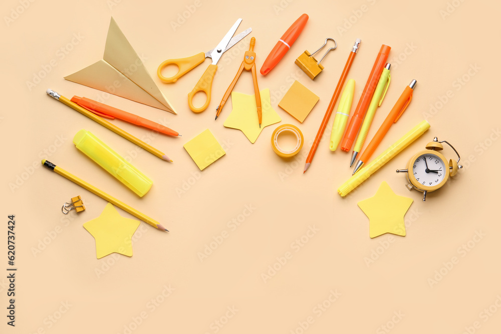 Set of different stationery and alarm clock on color background