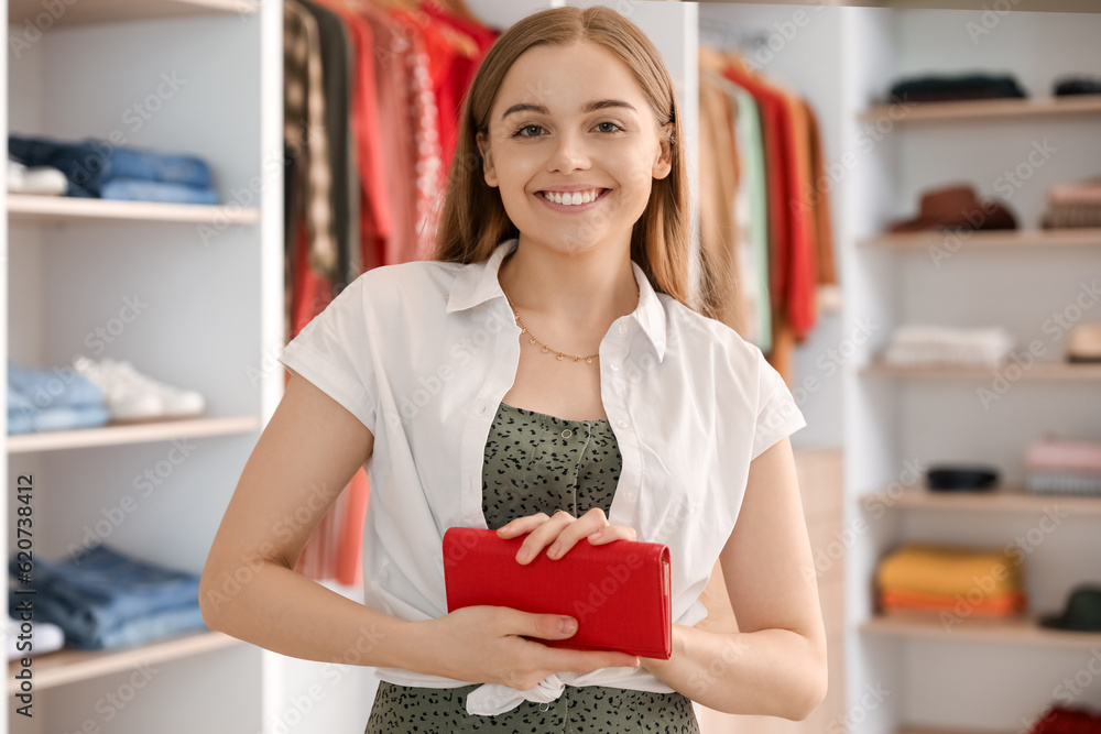 Young woman with wallet in boutique