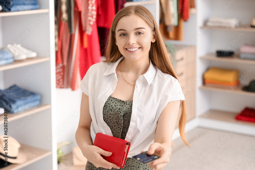 Young woman with credit card and wallet in boutique