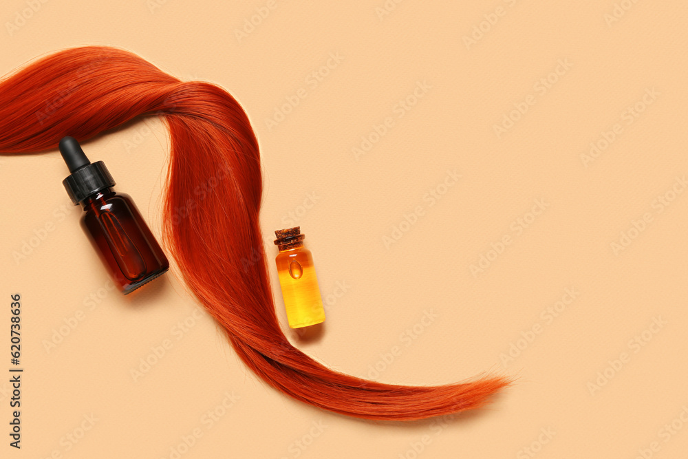 Ginger hair strand and bottles of essential oil on color background, closeup