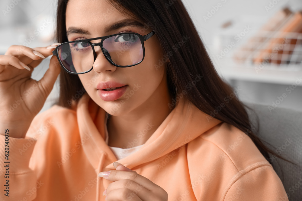 Beautiful young woman wearing glasses at home