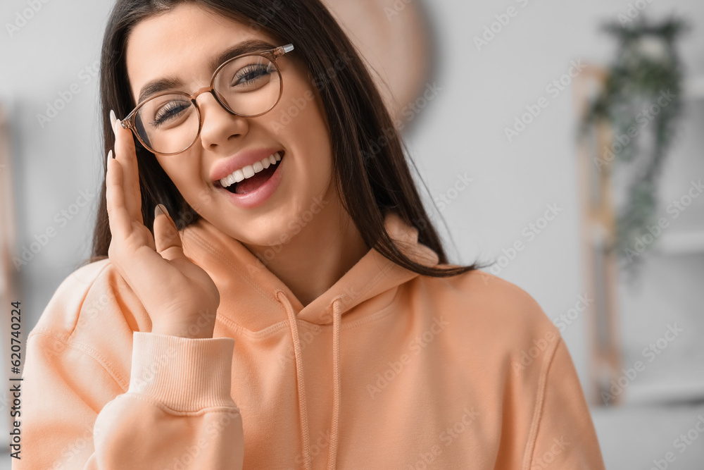 Beautiful happy young woman wearing glasses at home