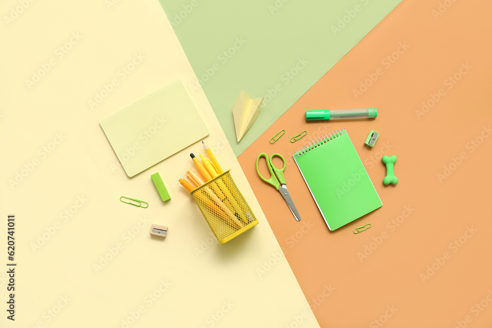 Composition with notebooks and different school stationery on color background