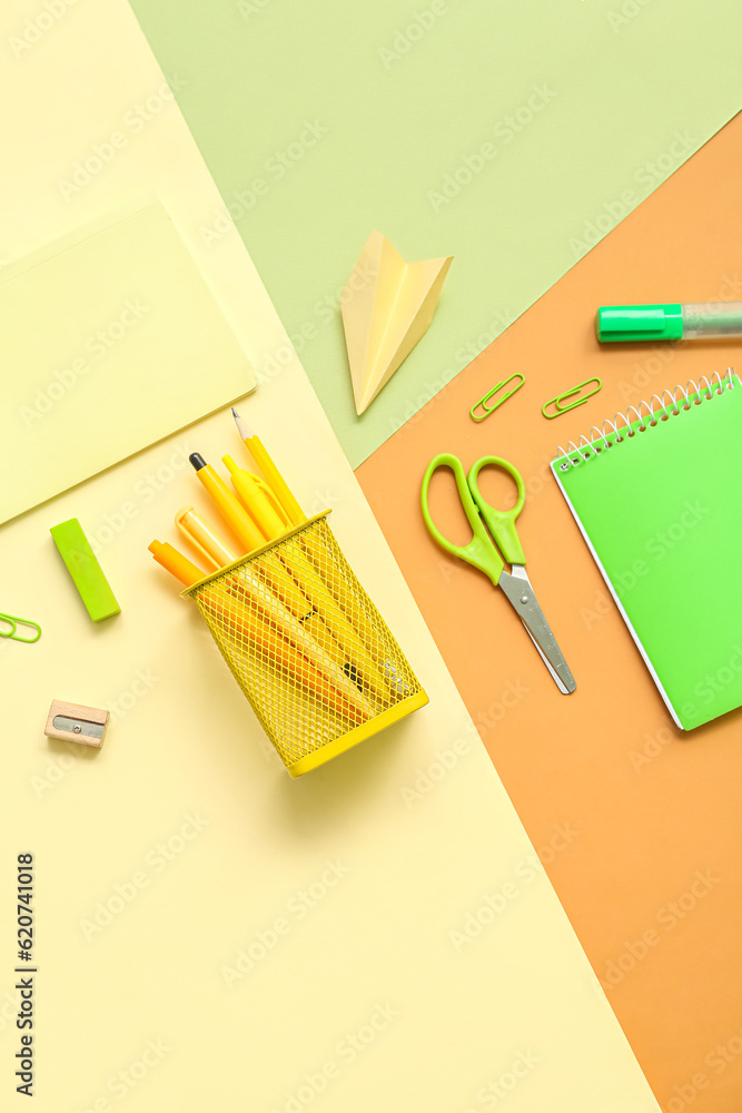 Composition with notebooks and different school stationery on color background