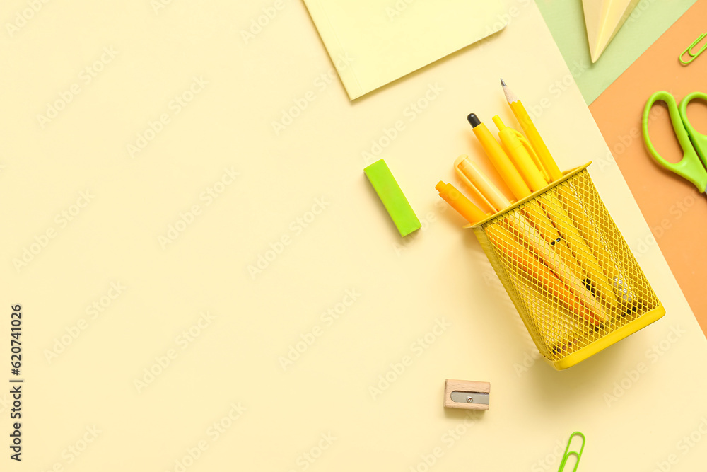 Cup with school stationery on color background