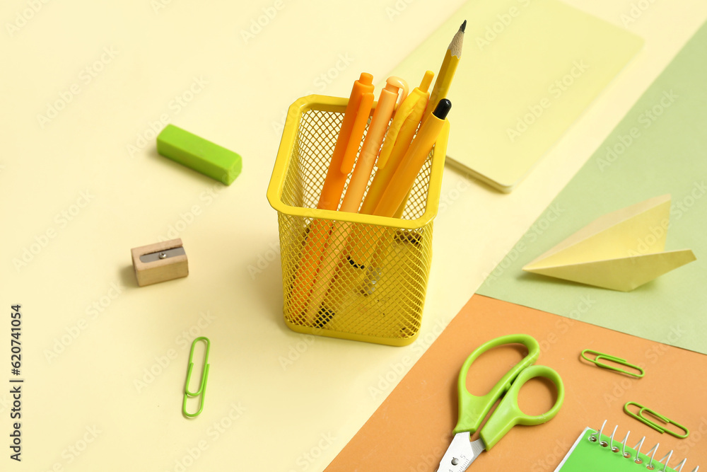 Cup with school stationery on color background, closeup